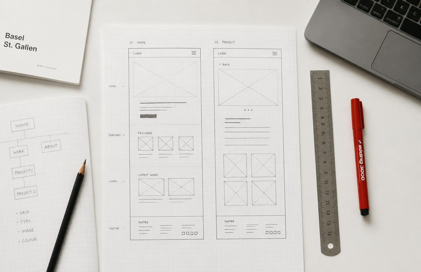Wireframe sketches, grid paper and drawing tools laid out on a desk
